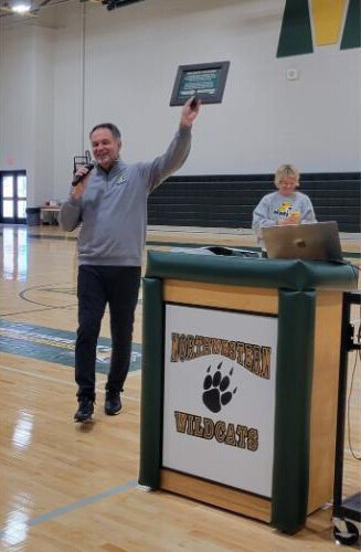 NMU Chief Marketing Officer Derek Hall presents the Wildcat Pledge at the pep rally. 