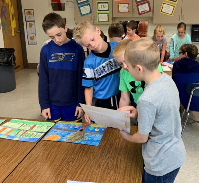 Schoolchildren from Michigan review their drawings to be sent to China.