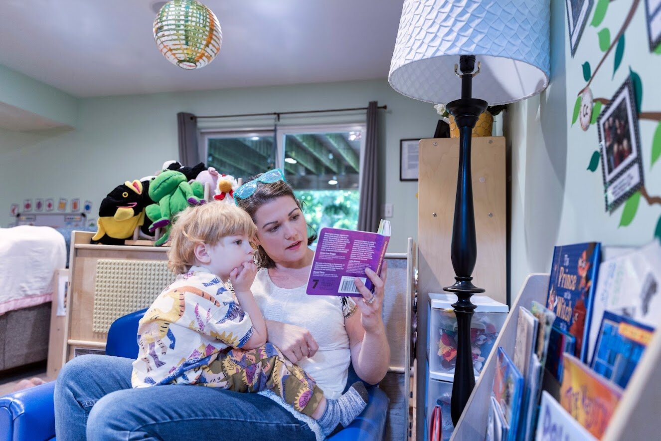 Trisha Dart reads a story to a child in her home-based preschool.