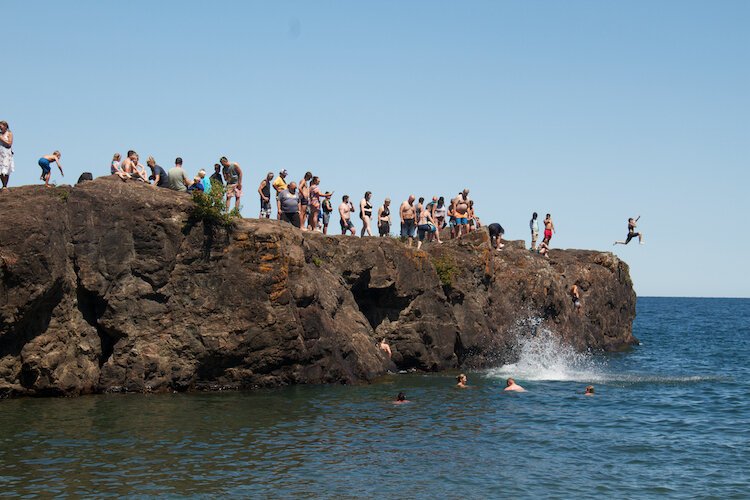 Divers take the plunge into Lake Superior from Black Rocks at Presque Isle Park.