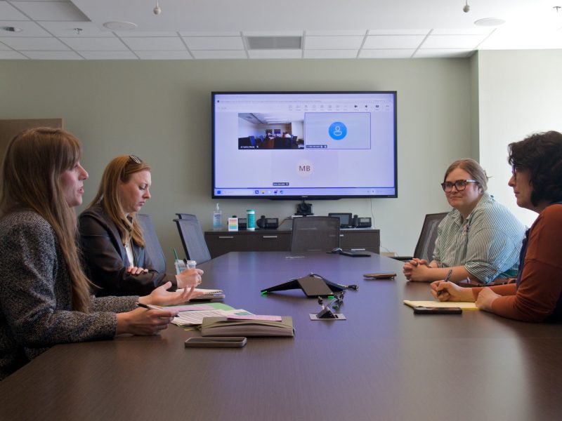 Chelsie Wilkinson, Megan Murphy, Nicky Bates, and Lisa Long meet to discuss Room at the Inn's recuperative care project.